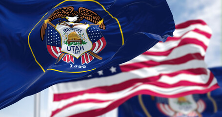 The Utah state flag waving along with the national flag of the United States of America