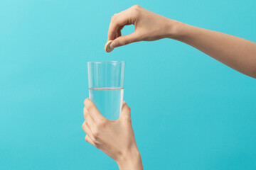 a female hand drops an effervescent tablet