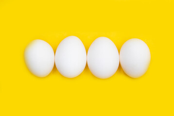 white chicken egg isolated on yellow background