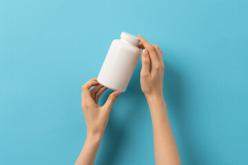 Female hand holding bottle of medication pills