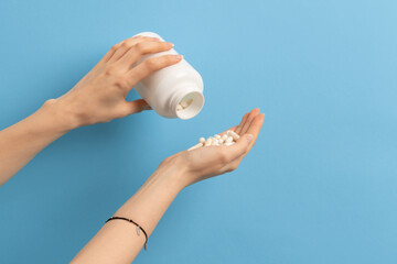 Female spilling over white pills or vitamins