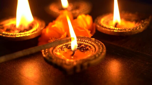 Colorful Diwali oil lamps, Deepavali oil lamps lighted in beautiful formation with flowers in middle. Oil lamps with sparkler. Motion of igniting hand held sparkler crackers