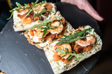 Bruschetta with shrimp sauce, sun-dried tomato and arugula