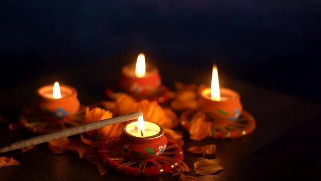 Colorful Diwali oil lamps, Deepavali oil lamps lighted in beautiful formation with flowers in middle. Oil lamps with sparkler. Motion of igniting hand held sparkler crackers