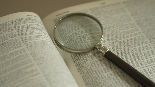 Magnifying glass on large opened book