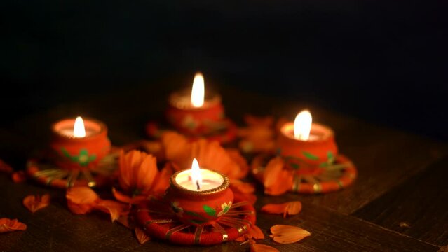 Colorful Diwali oil lamps, Deepavali oil lamps lighted in beautiful formation with flowers in middle. Oil lamps with sparkler. Motion of igniting hand held sparkler crackers