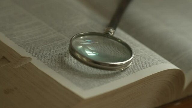 Magnifying glass on large opened book