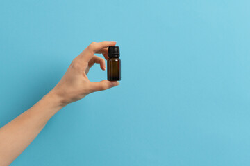 Fototapeta premium Female hand holding a jar of medication liquid