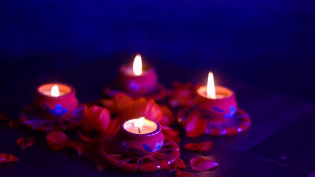 Colorful Diwali oil lamps, Deepavali oil lamps lighted in beautiful formation with flowers in middle. Oil lamps with sparkler. Motion of igniting hand held sparkler crackers