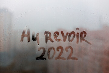 lettering Au revoir in French is goodbye in english and numbers 2022 paint with finger of water on...