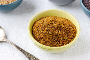 Powder spice blend from black and white mustard seeds and turmeric. Indian mustard powder seasoning in bowl.