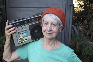 Mature female break dancer holding large speaker system