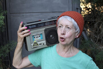 Mature female break dancer holding large speaker system