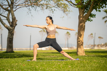 Athletic young woman doing yoga in the Park in the morning.