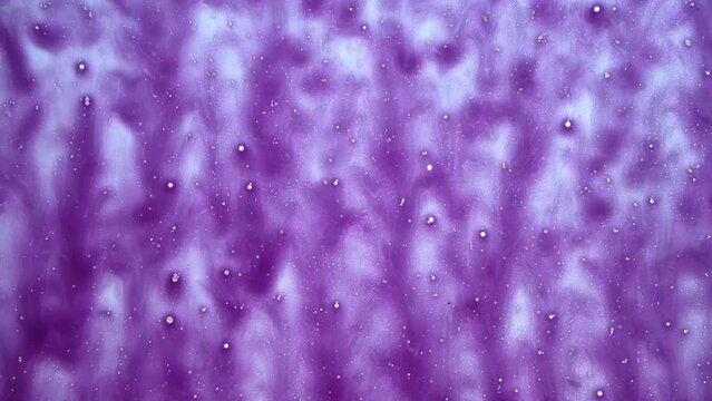 Cleaning foam on a car glass. Soapy window. Car wash service station. View from inside a cabin. Abstract background purple color. High pressure gun with shampoo. Flowing texture close-up. Abstraction.