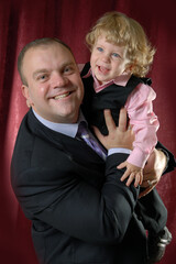 Portrait of a fair-haired girl with a curly, blue-eyed, little boy in a pink shirt and black...