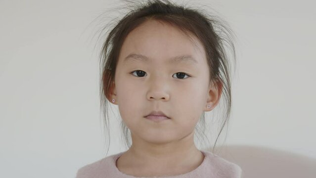 Portrait of a cute Asian girl child looking straight into the camera
