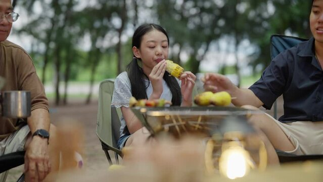 Asian family happy with Bar-B-Q time. Medium family travel together on holiday weekend. best vacation kids happy with family spending time together doing grill BBQ on beach campfire camping.