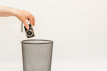 The broken digital camera is thrown into the trash for recycling.White,gray background,selective focus,copy space.