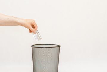 The medicine is thrown away into the basket trash,for disposal and recycling.White,gray background,selective focus,copy space.