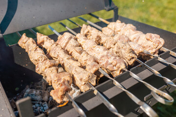 Pieces of pork skewers on a metal grill. Sundried pork is a food.Closeup.