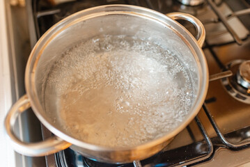 Boiling water inside a pot.Kitchen iron pot,top view,selective focus.