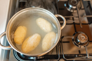Traditional Lithuanian stuffed potato dumplings in the pot water. The dumplings are made from grated and riced potatoes and stuffed with ground meat.Indoors shot.