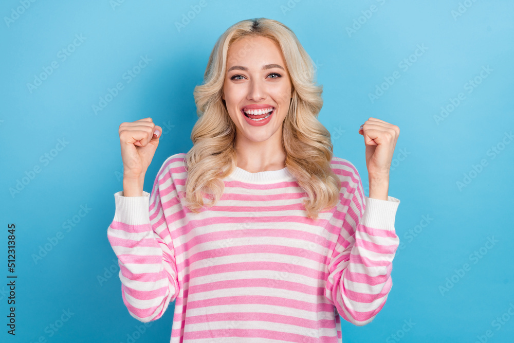 Sticker Photo of lucky funny lady dressed pink pullover rising fists smiling isolated blue color background