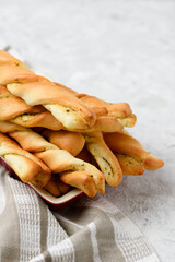 Low depth of field photo of twisted bread sticks with spices on napkin on light table. Close up homemade pastries with stuffing