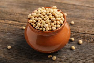 Dry soyabean seed in bowl on wooden background.