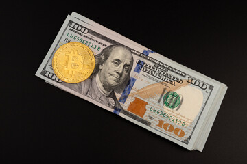 Gold bitcoin coin standing in front of dollar bills. New virtual money concept. Concept of digital...