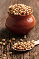 Dry soyabean seed in bowl on wooden background.