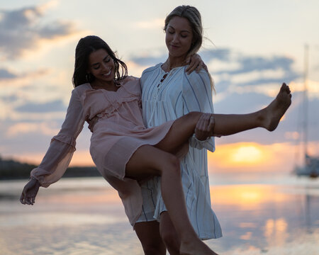 Dos chicas pasando un dia en la playa en bikini y traje de ba&ntilde;o 