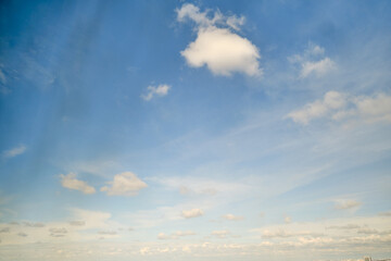 White cumulus clouds in the blue sky. Bright beautiful sky, copy space background