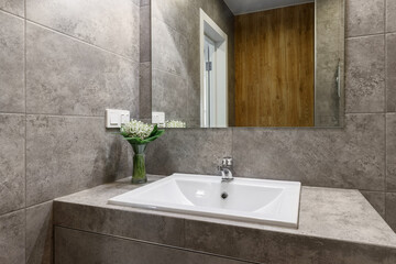 Bathroom washbasin with bouquet of lilies of the valley