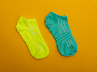 Two pairs of multicolored socks on a yellow background.