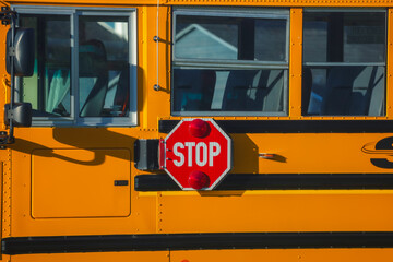 Close up of an octagon shaped red stop sign with signal lights on a school bus