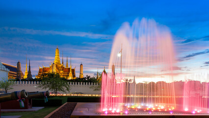 Fototapeta na wymiar Fountain with the temple of emerald buddha at Dusk (Bangkok, Thailand)