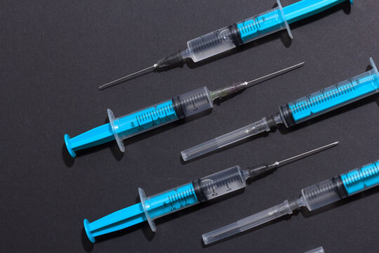 Medical plastic vaccination syringe isolated on a black background