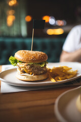Man eating a burger. Close-up of a burger on the table. Fast food. Man eating a cheeseburger....