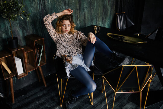 High angle portrait of young girl wearing grunge outfit looking at camera with intense face expression