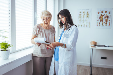 Smiling caring young female nurse doctor caretaker assisting happy senior grandma helping old patient in rehabilitation recovery at medical checkup visit, elder people healthcare homecare concept