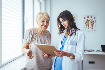Smiling caring young female nurse doctor caretaker assisting happy senior grandma helping old...