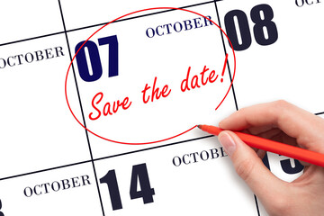 Hand drawing red line and writing the text Save the date on calendar date October 7.
