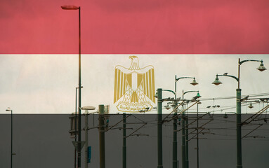 Egypt flag with tram connecting on electric line with blue sky as background, electric railway train and power supply lines, cables connections and metal pole overhead catenary wire