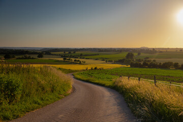 A golden sunset over the rolling hills of south Limburg in the Netherlands creating holiday vibes. The views and the warm glow over the landscape create a feeling of being in the Mediterranean.