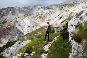 Fototapeta na wymiar Female Hiker Admiring Alpine View From a Hiking Trail in Julian Alps