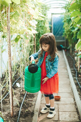 Little girl with big watering can