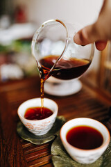 China pours strong black tea from the teapot