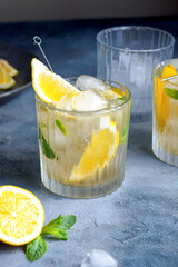 citrus lemonade with mint and lemon in the glass with ice cubes.